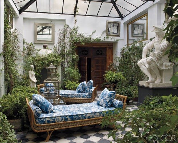 In the courtyard, 1960s Jansen daybeds are upholstered in a Madeleine Castaing fabric, the cast of a Michelangelo sculpture is from a Paris flea market, and the Gothic Revival doors are 19th-century Spanish.