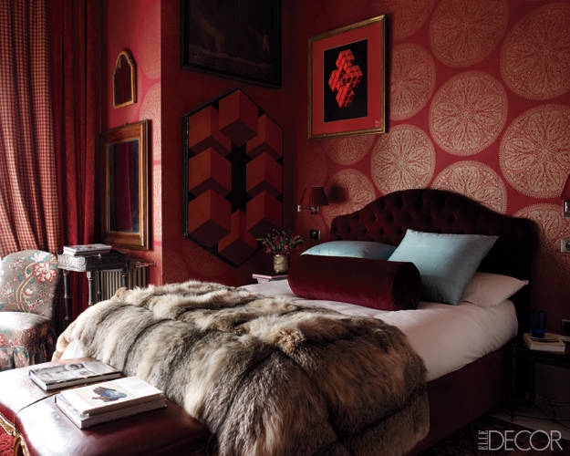 In the guest bedroom, a headboard upholstered in a Valentino velvet, a Louis XV–style bench, and 17th- and 18th-century Spanish mirrors; the paintings are by ­Yturralde, and the wallpaper is by Sanderson.