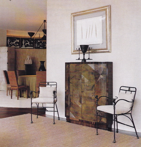 A painting by Lucio Fontana hangs above a Jean Dunand cabinet in the entry.