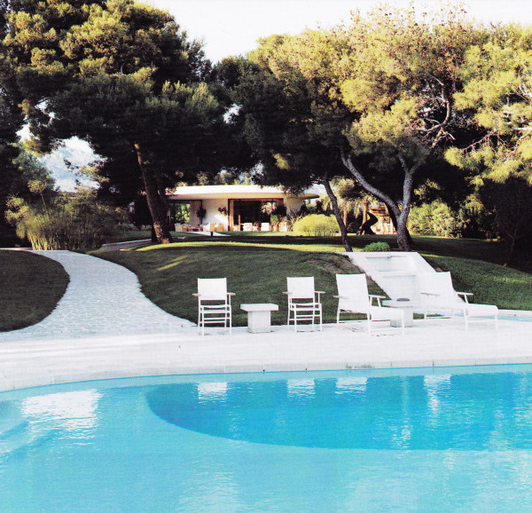 The main house can be viewed beyond the amorphous shaped swimming pool.