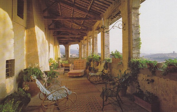 An expansive terrace affording views of the Sabine Hills is furnished with ancient cane furniture in a photo taken by James Mortimer in the 1980's.