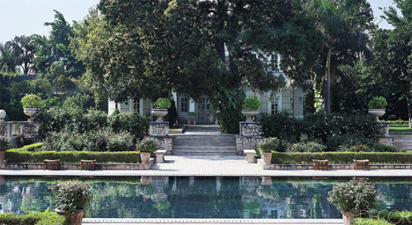 Indian limestone steps lead to the poolhouse, which is surrounded by rose bushes; Deniot designed the limestone benches and teak stools. Photo by Richard Powers.