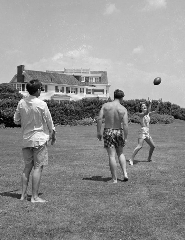 John F. Kennedy, Jacqueline Kennedy, and Edward Kennedy play football on the lawn, 1953. Photo by Ron Galella.
