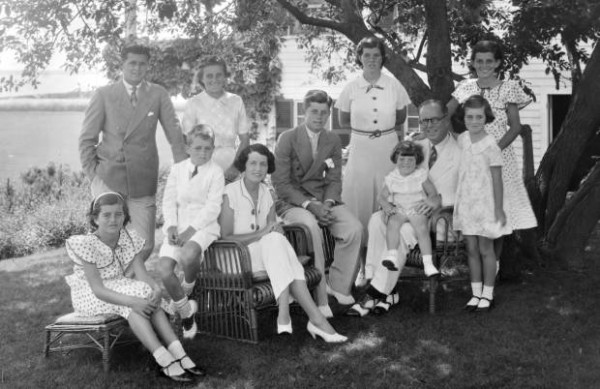 A portrait of the Kennedy family a their compound in Hyannis Port. Seated from left are: Patricia Kennedy, Robert Kennedy , Rose Kennedy, John F Kennedy, Joseph P Kennedy Sr. with Edward Kennedy on his lap; standing from left are: Joseph P Kennedy Jr., Kathleen Kennedy, Rosemary Kennedy, Eunice Kennedy, and Jean Kennedy. 