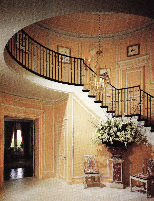 Henri Samuel had the entrance hall painted salmon. A Languedoc marble jardiniere from Versailles stands bewteen two Indian chairs in ivory-veneered fruitwood.