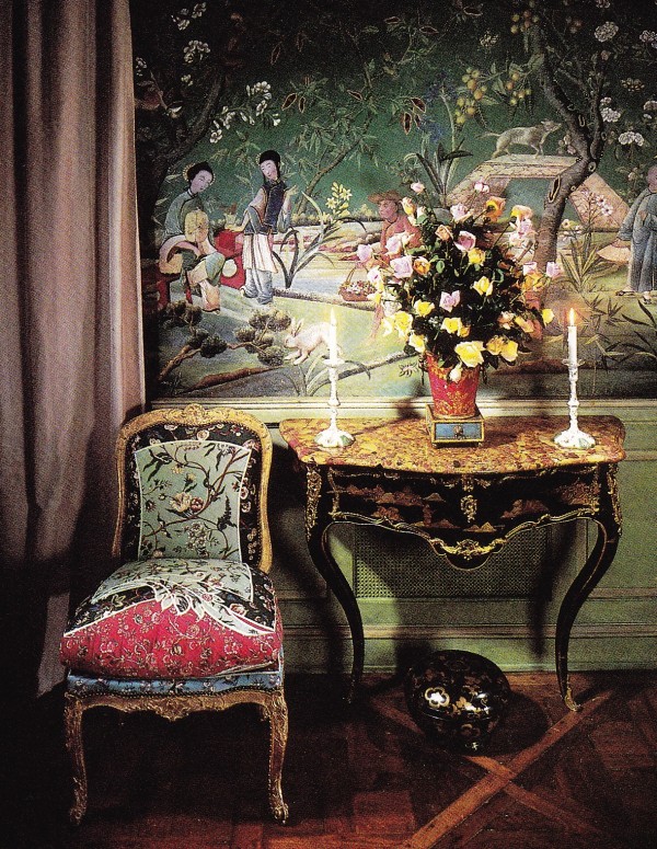 The table is Louis XV in black and gold vernis martin with figures in the Chinese taste. On top are Battersea white and green enamel candlesticks and an 18th-century tole vase filled with roses from the garden.